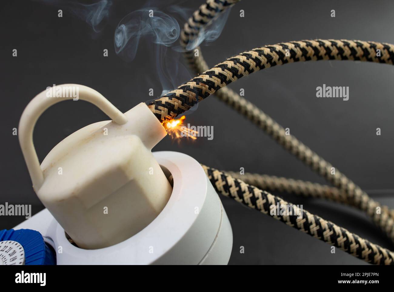 flame smoke and sparks on an electrical cable with fabric insulation
