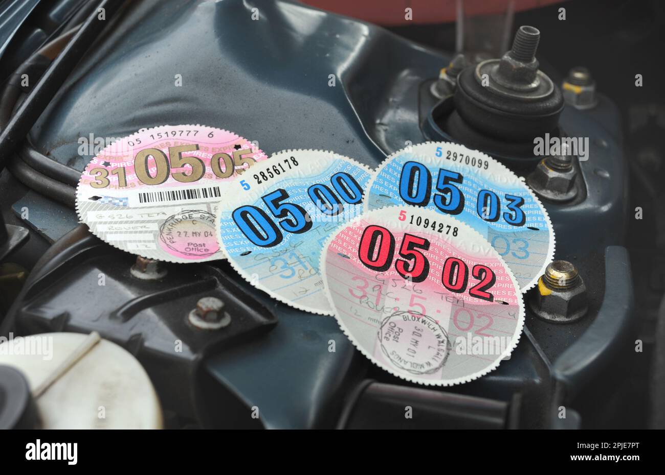 CAR TAX DISCS IN CAR ENGINE BAY RE VED VEHICLE EXCISE DUTY ROAD TAX MOTORING COSTS ETC UK Stock Photo
