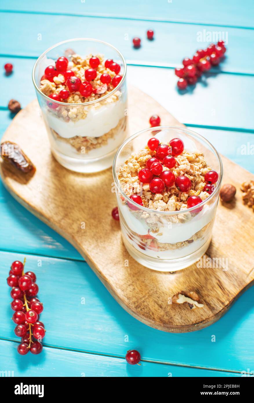 Healthy breakfast menu concept. Morning granola breakfast with berries served with yogurt in glasses. Stock Photo