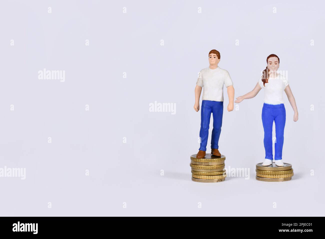 Gender pay gap concept with man and woman standing on different amount of coins with copy space Stock Photo
