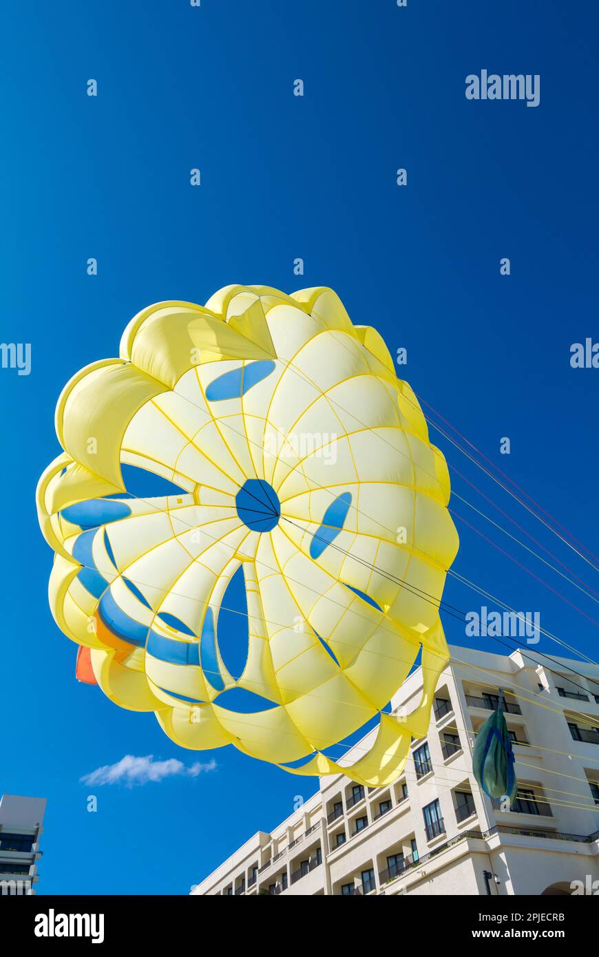 Cancun, Quintana Roo, Mexico, A yellow paragliding  in the blue sky Stock Photo