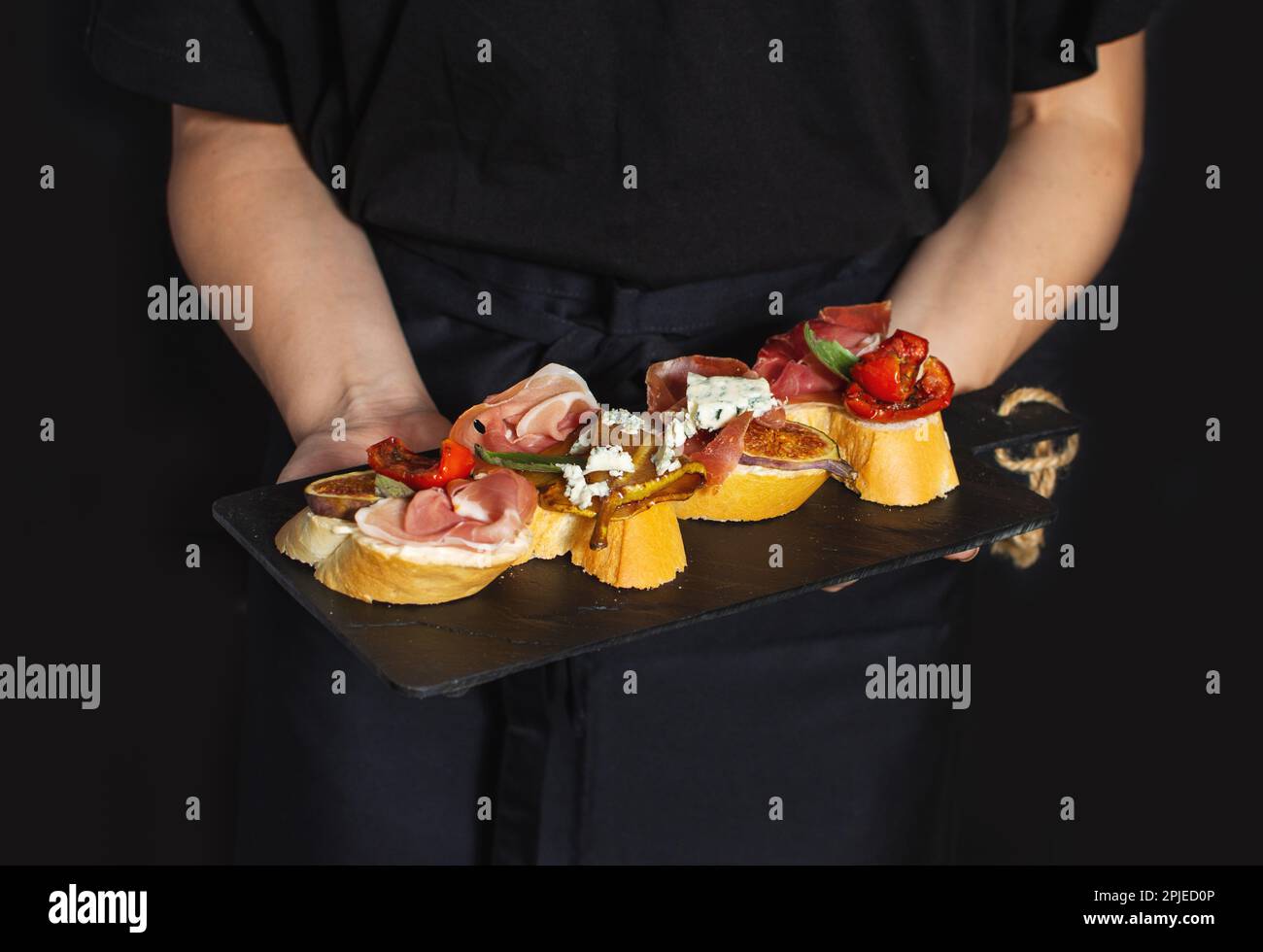 Board of appetizers with a traditional spanish set of tapas in the hands of chef Stock Photo