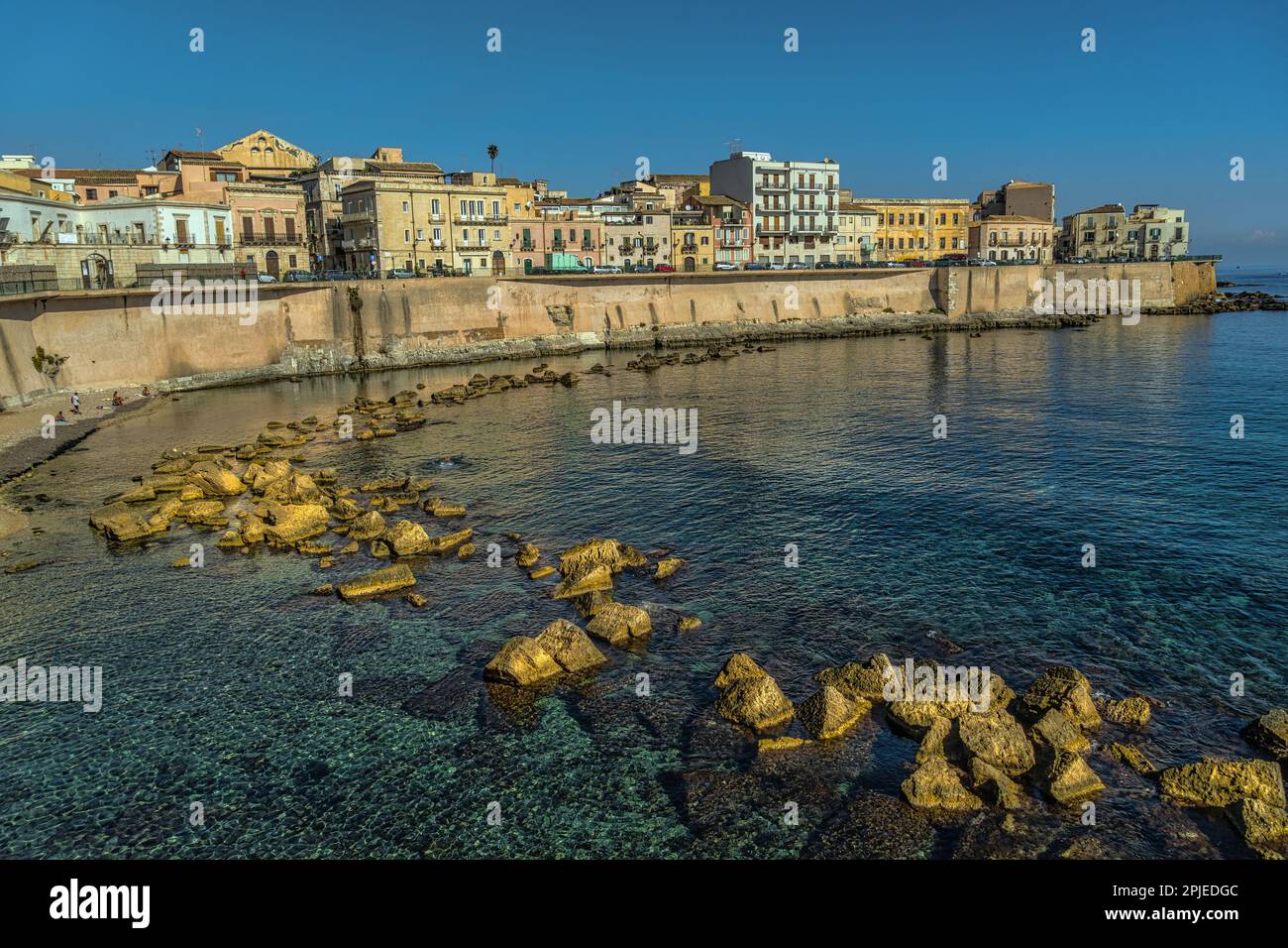 Ancient and modern buildings overlooking the seafront of Ortigia at Cala Rossa beach. Syracuse, Sicily, Italy, Europe Stock Photo
