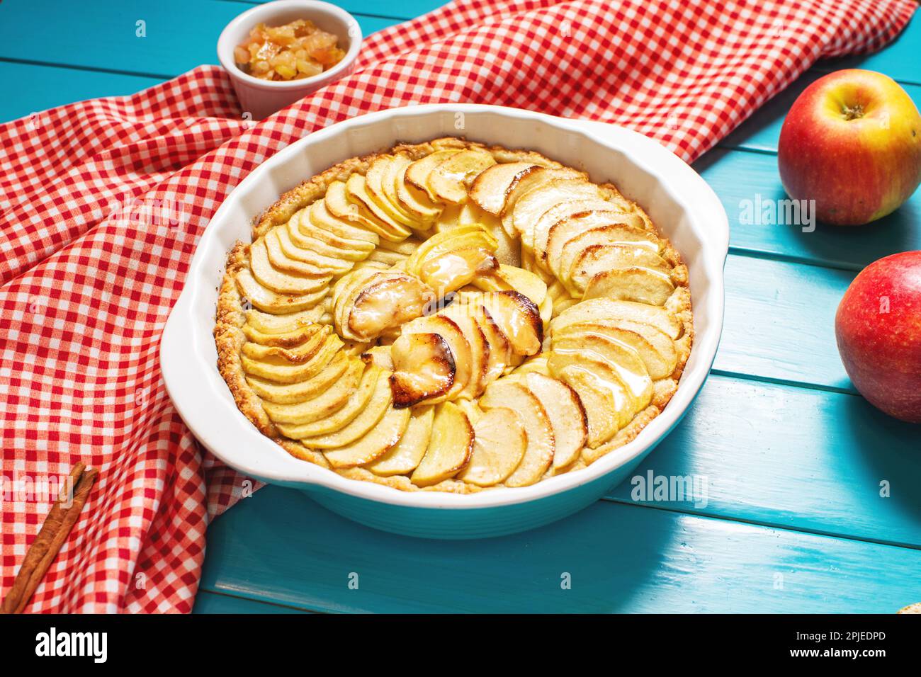 Homemade delicious fresh baked rustic apple pie on blue wooden background. Stock Photo