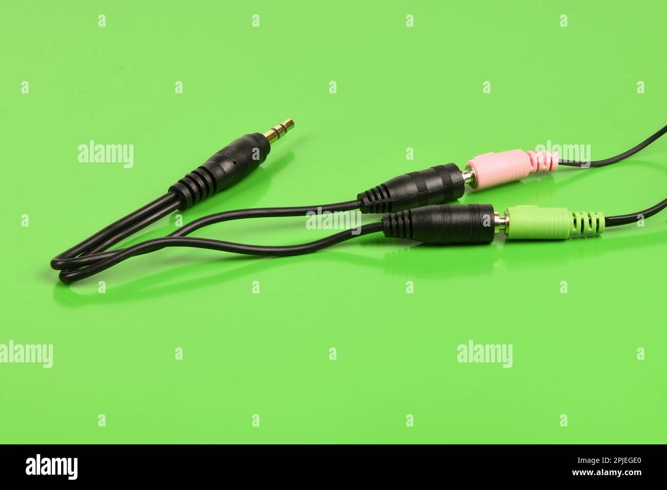 Audio cable splitter, stereo male to two female stereo audio jack 3,5 mm, isolated on a green background. Extreme closeup. High resolution photo. Full Stock Photo