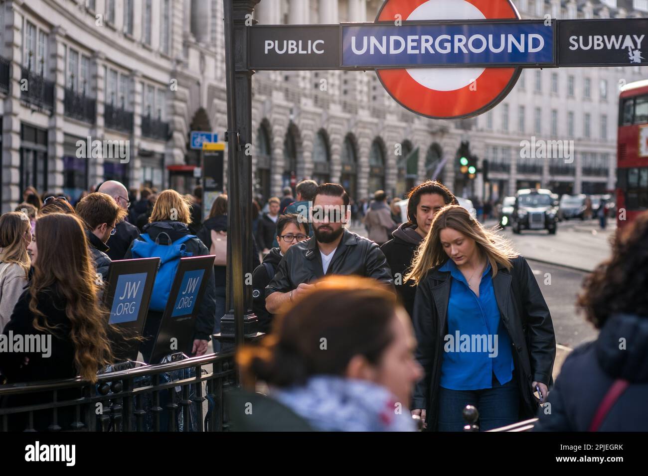 Commuters descend into Piccadilly Circus underground tube station on a busy day with a busy Regents Street in the background, Central London, 2023. Stock Photo