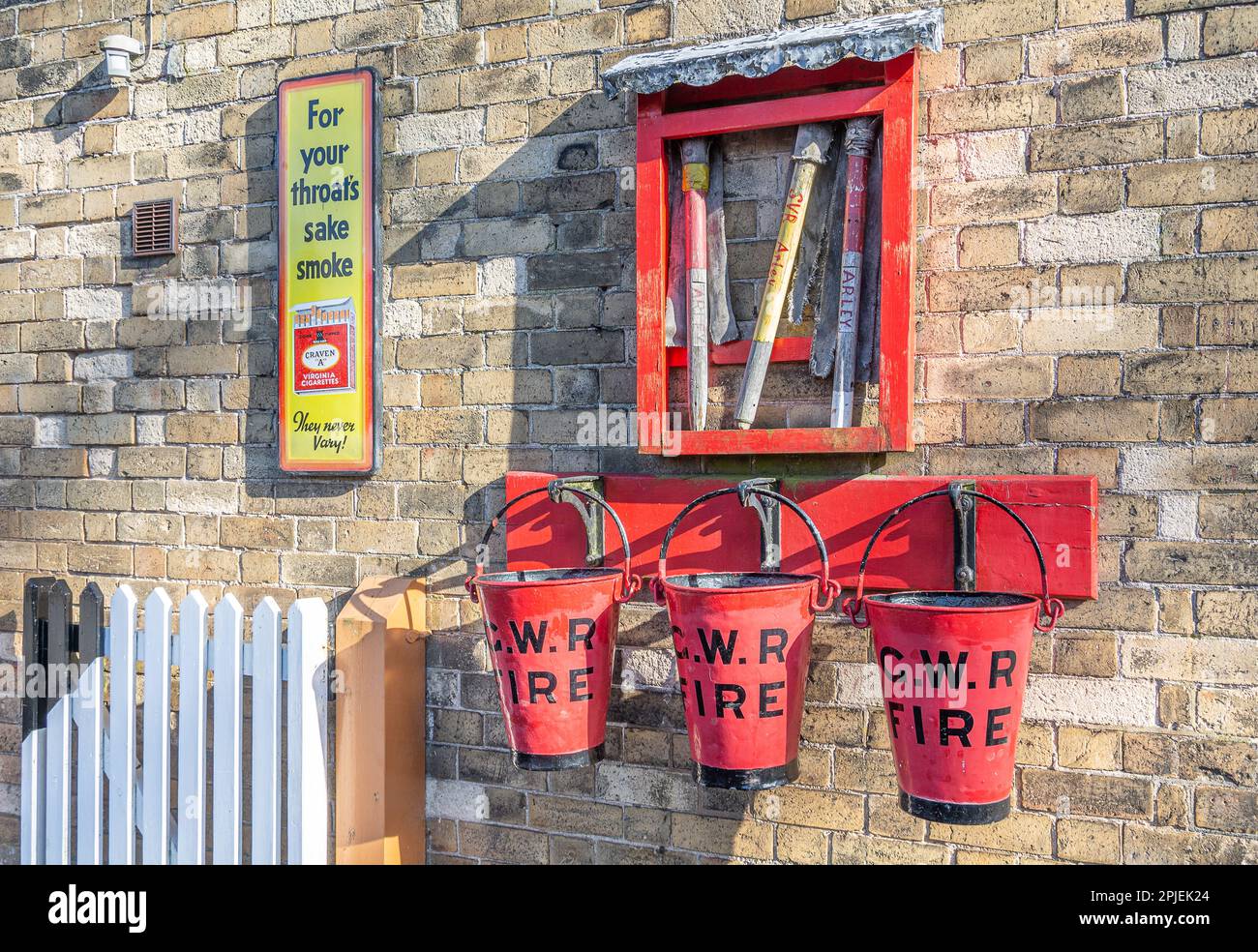 Fire buckets and equipment alongside an old  smoking advert at Arley Station  on the Severn Valley Steam Railway, Worcestershire, England Stock Photo
