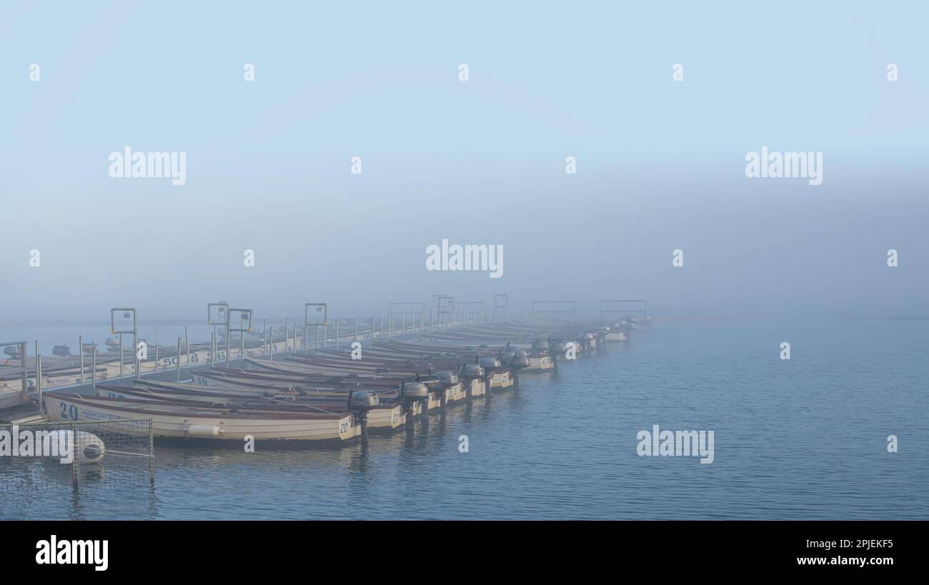 Hire Boats Lined Up In The Fog On Grafham Water Cambridgeshire hire-boats-lined-up-in-the-fog-on-grafham-water-cambridgeshire