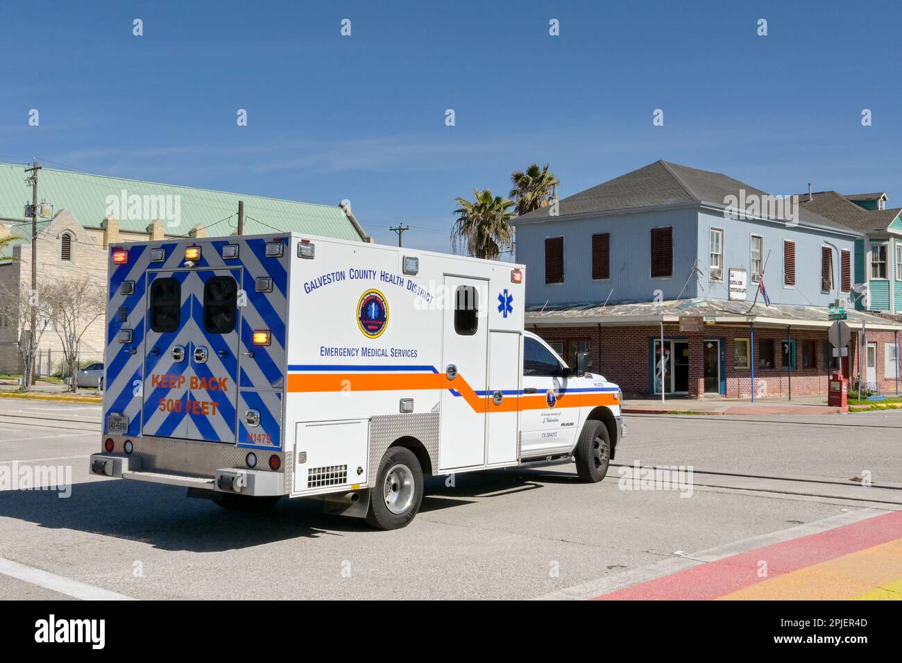 Galveston, Texas, USA - February 2023:  Emergency ambulance with lights flashing driving on one of the city's streets Stock Photo