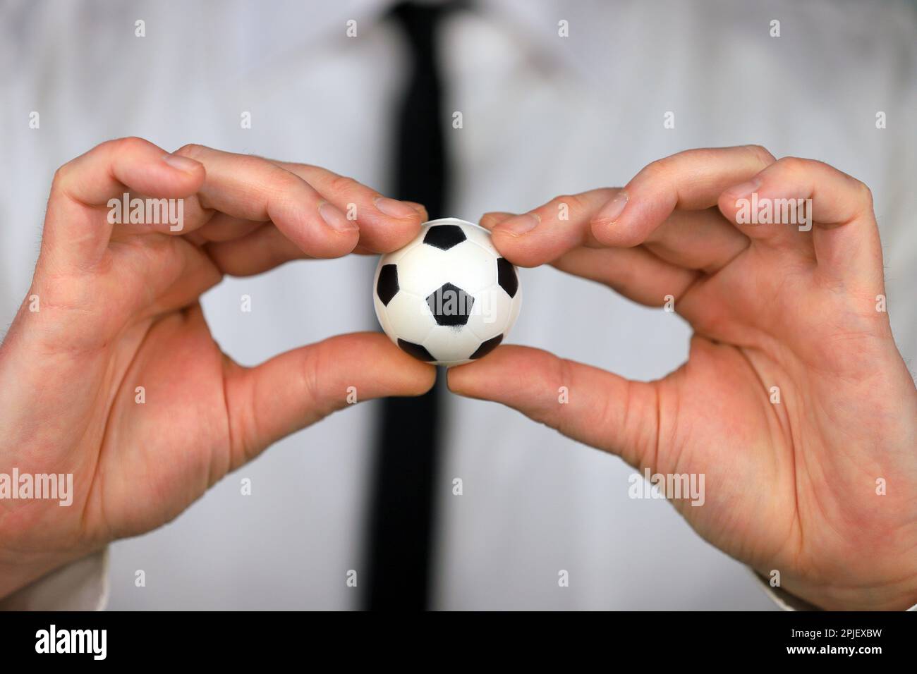 A businessman in a white shirt and black tie holding football ball in his hands Stock Photo Alamy
