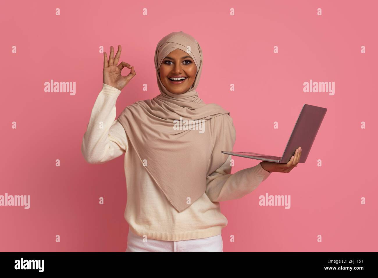 Happy Muslim Woman In Hijab Holding Laptop And Gesturing Ok Stock Photo ...