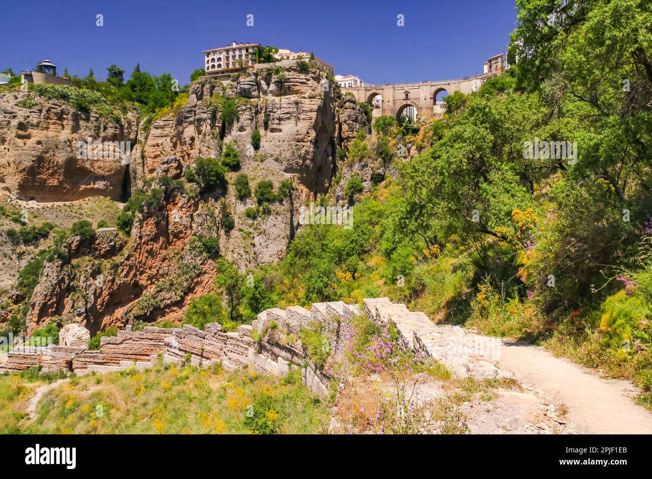 The massive rock wall at the famous bridge Puente Nuevo in the Andalusian city of Ronda in the province of Malaga, Spain Stock Photo