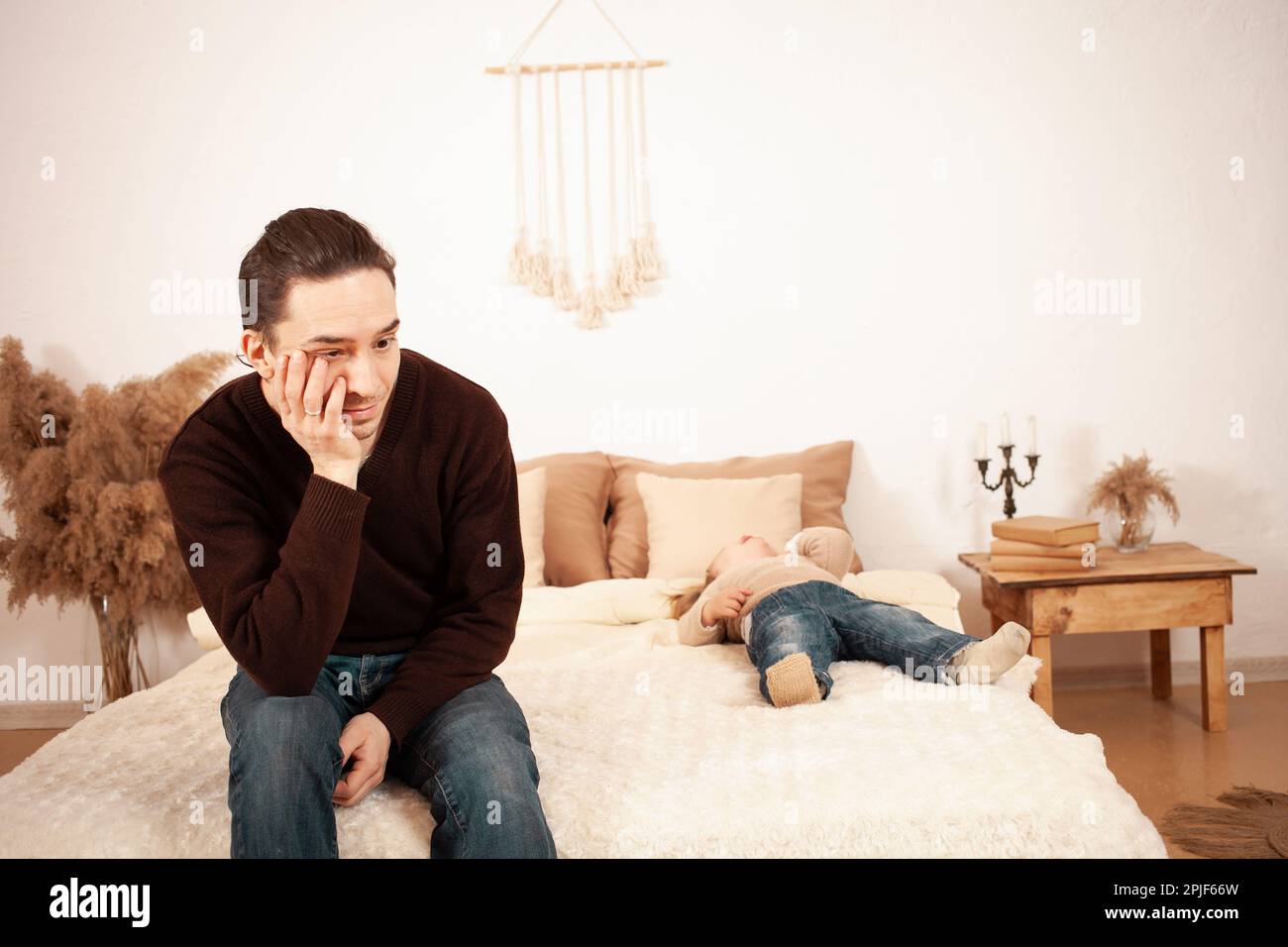 Dad can not cope with the child, a twoyearold girl lies on the bed