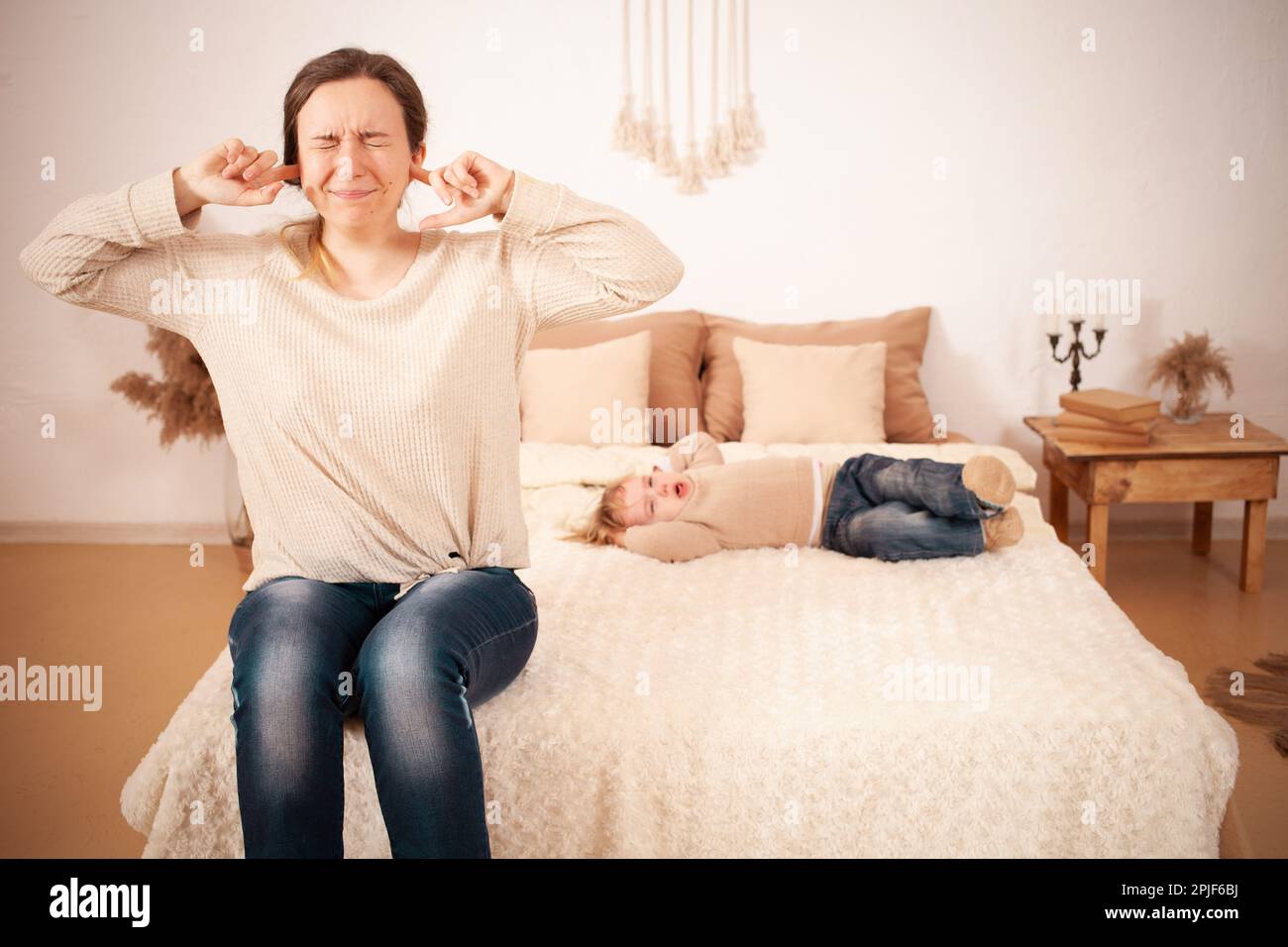 Mom's tired of the baby. A twoyearold girl lying on the bed