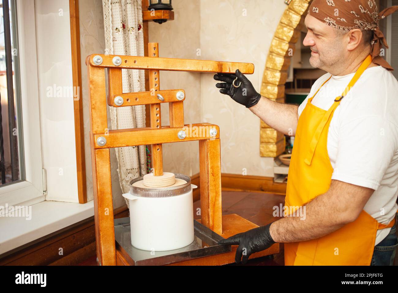 The cheesemaker puts cheese under press, whey. Home production ...