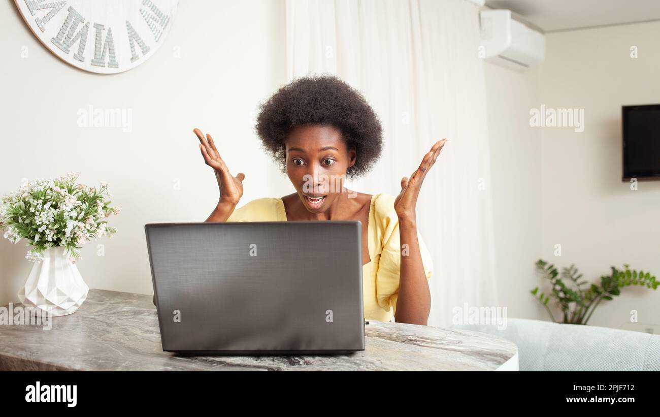 a African American Black Woman Portrait House. Indoor, woman is surprised, stunned, angry, mouth open. Winning, bug, laptop broken, lottery, job vacan Stock Photo