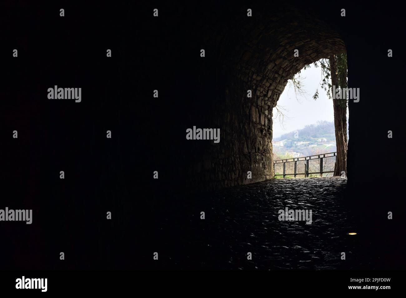 Dark and covered passage in the boundary wall of a castle Stock Photo ...