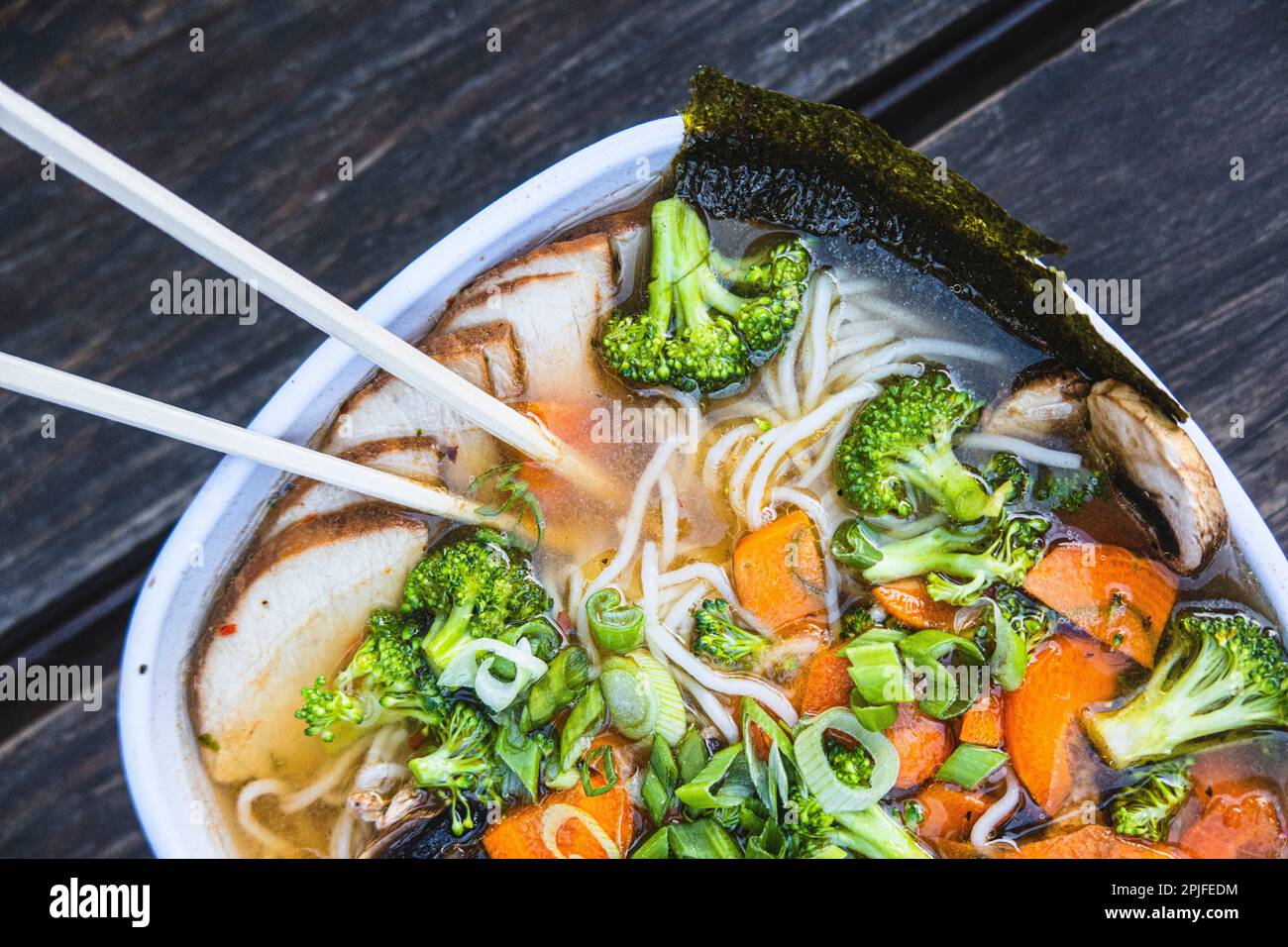 A bowl of ramen with chopsticks and broccoli on top Stock Photo Alamy
