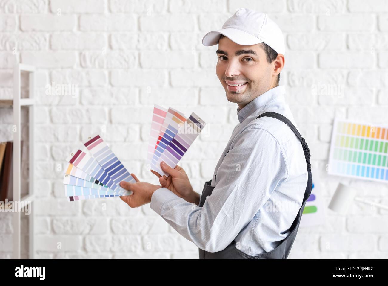 Male painter with color palettes near white brick wall Stock Photo Alamy