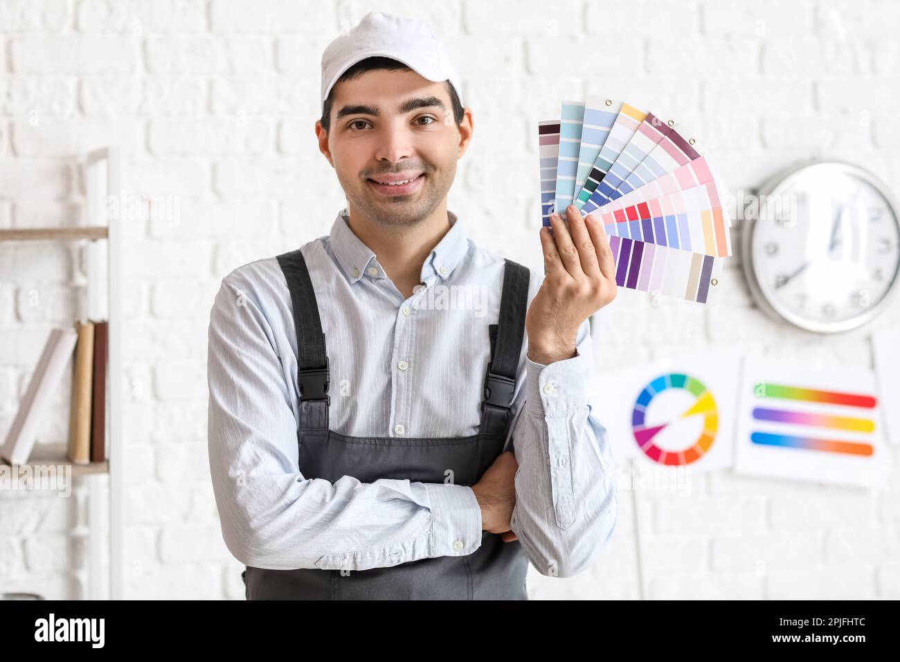 Male painter with color palettes near white brick wall Stock Photo Alamy