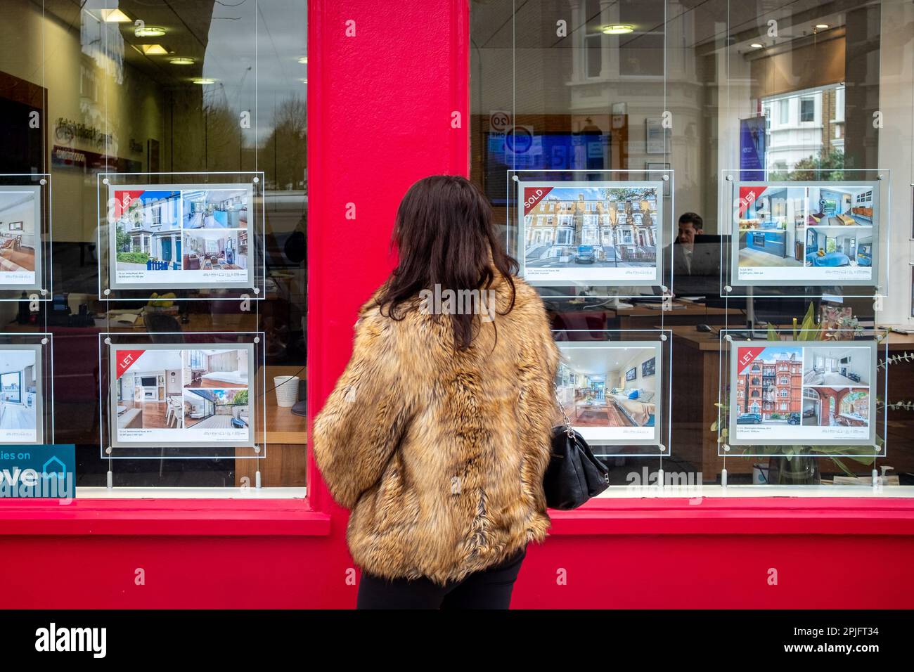 London February 2023 Young woman looking at house adverts in estate