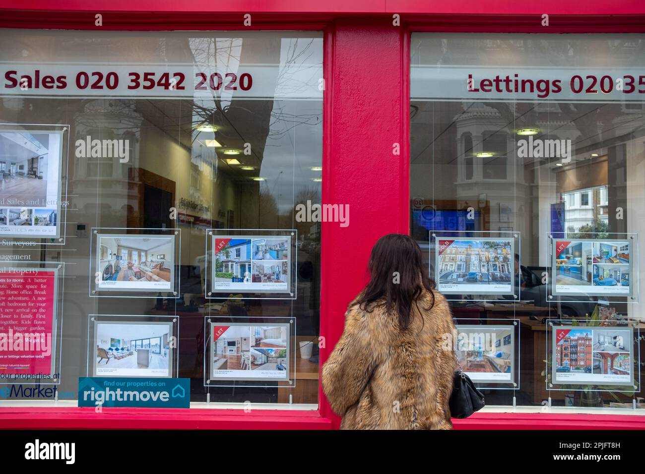 London February 2023 Young woman looking at house adverts in estate