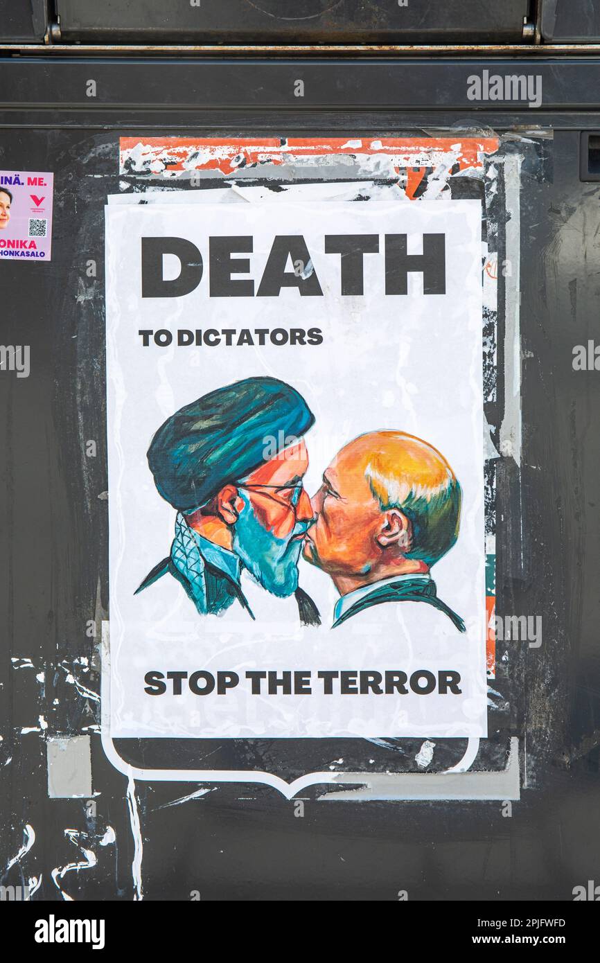 Death to Dictators. Stop the Terror. Paste-up poster of Ali Khamenei and Vladimir Putin kissing on a public trash bin in Helsinki, Finland. Stock Photo