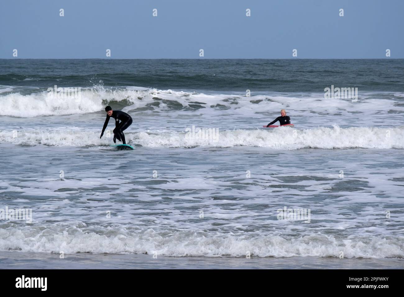 Dunbar, Scotland, UK. 2nd April 2023. People enjoying the Sunny but deceptively cold weather, along the East Lothian coastline at Belhaven Bay. Temperature around 5C in the the breeze. Surfing on the waves.  Credit: Craig Brown/Alamy Live News Stock Photo