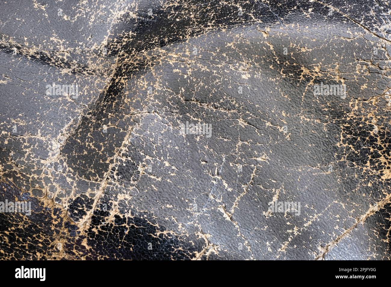 Cracked black fullgrain leather; worn and weathered to show surface