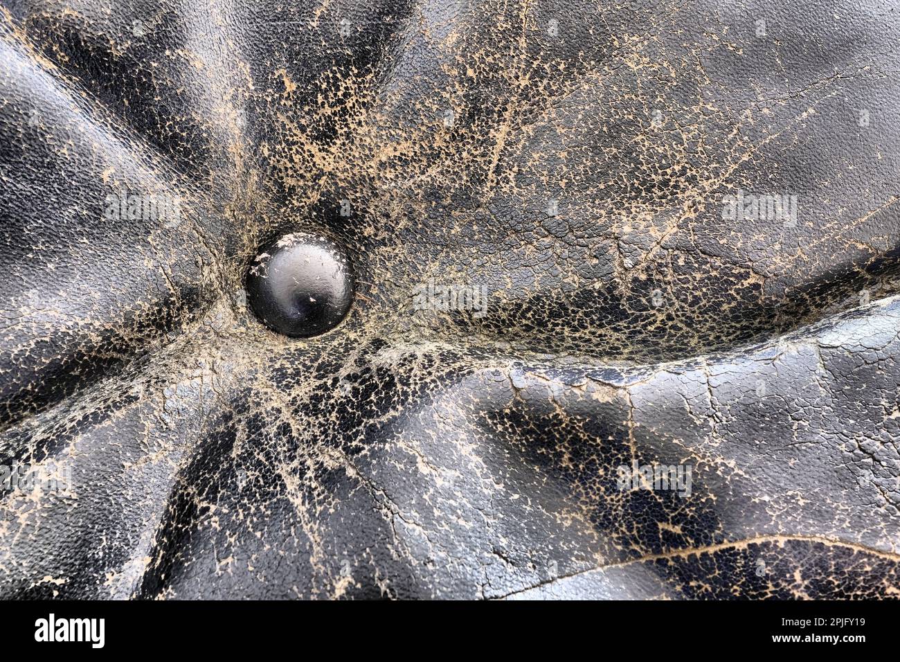 Button on cracked black fullgrain leather; worn and weathered