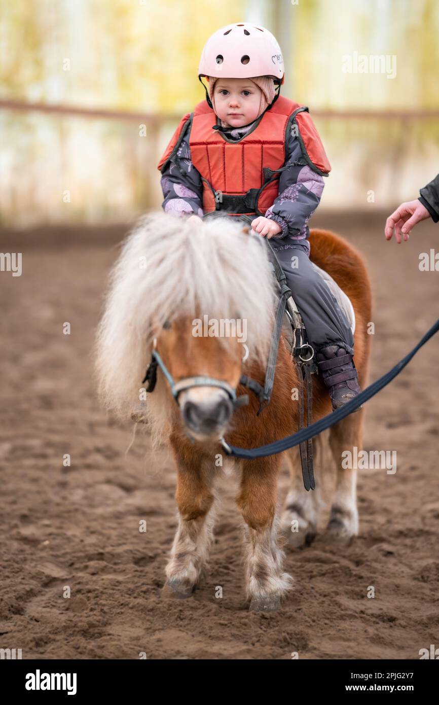 Little Child Riding Lesson. Threeyearold girl rides a pony and does
