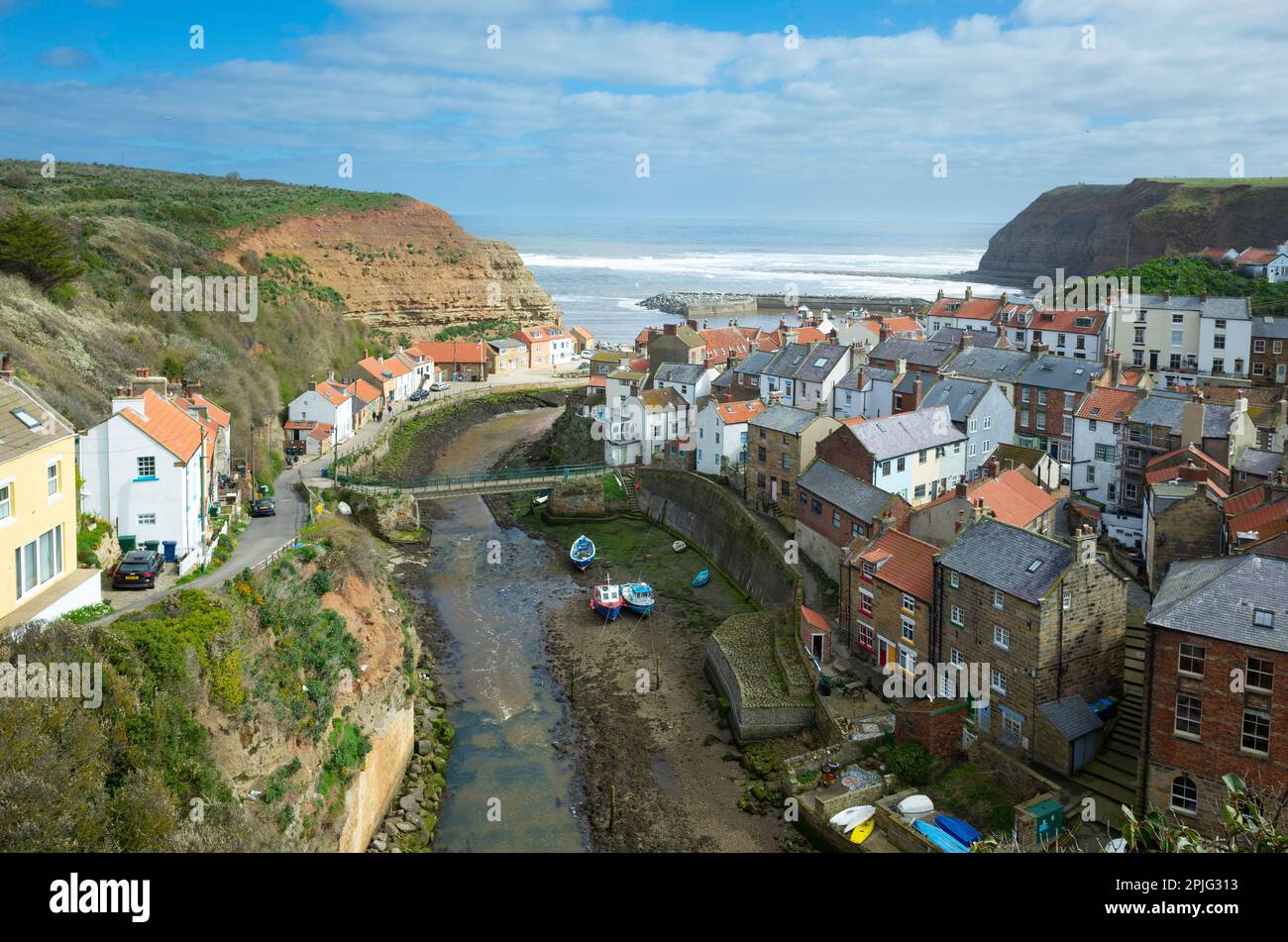 View looking seawards over the harbour of the North Yorkshire Village of Staithes with Cowbar on the North side of Roxby Beck detail showing lifeboat Stock Photo