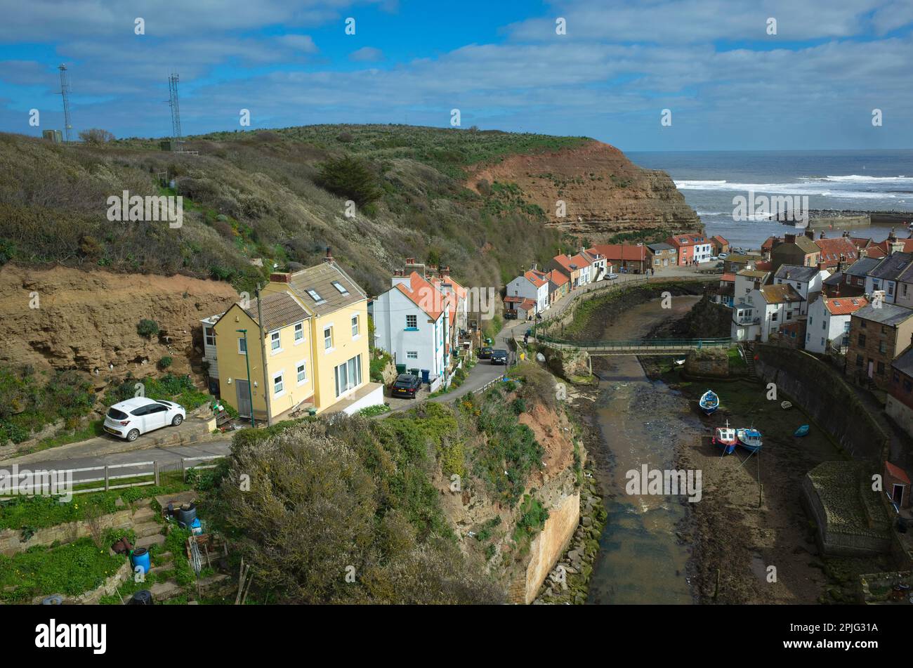 View looking seawards over the harbour of the North Yorkshire Village of Staithes with Cowbar on the North side of Roxby Beck detail showing lifeboat Stock Photo
