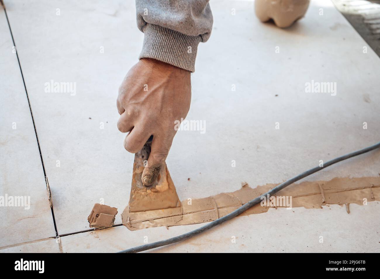 Mason passing the paste in the joint between tiles. I work in a