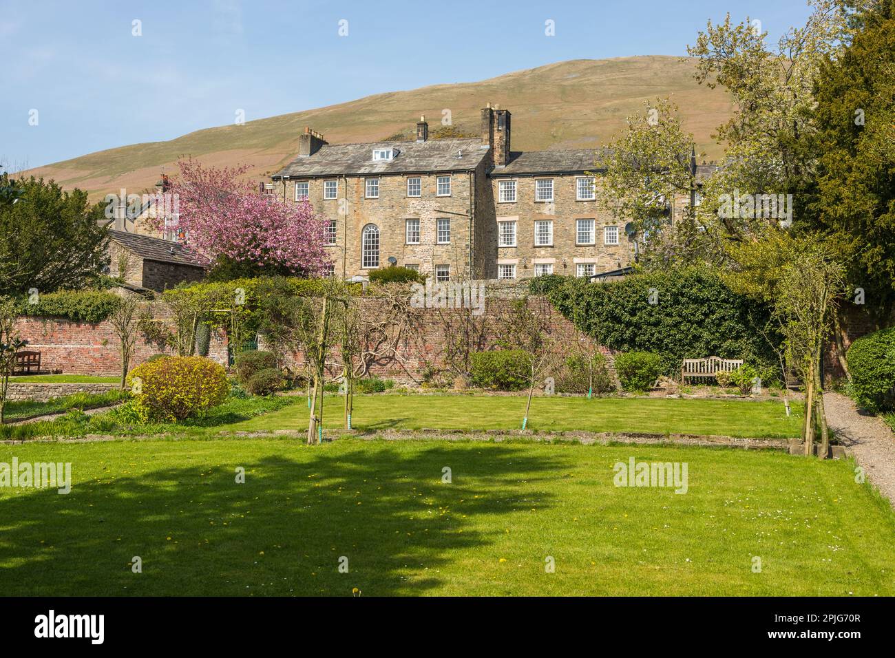 View of the buildings of the Sedbergh village. Beautiful garden. Sunny spring day. Sedbergh