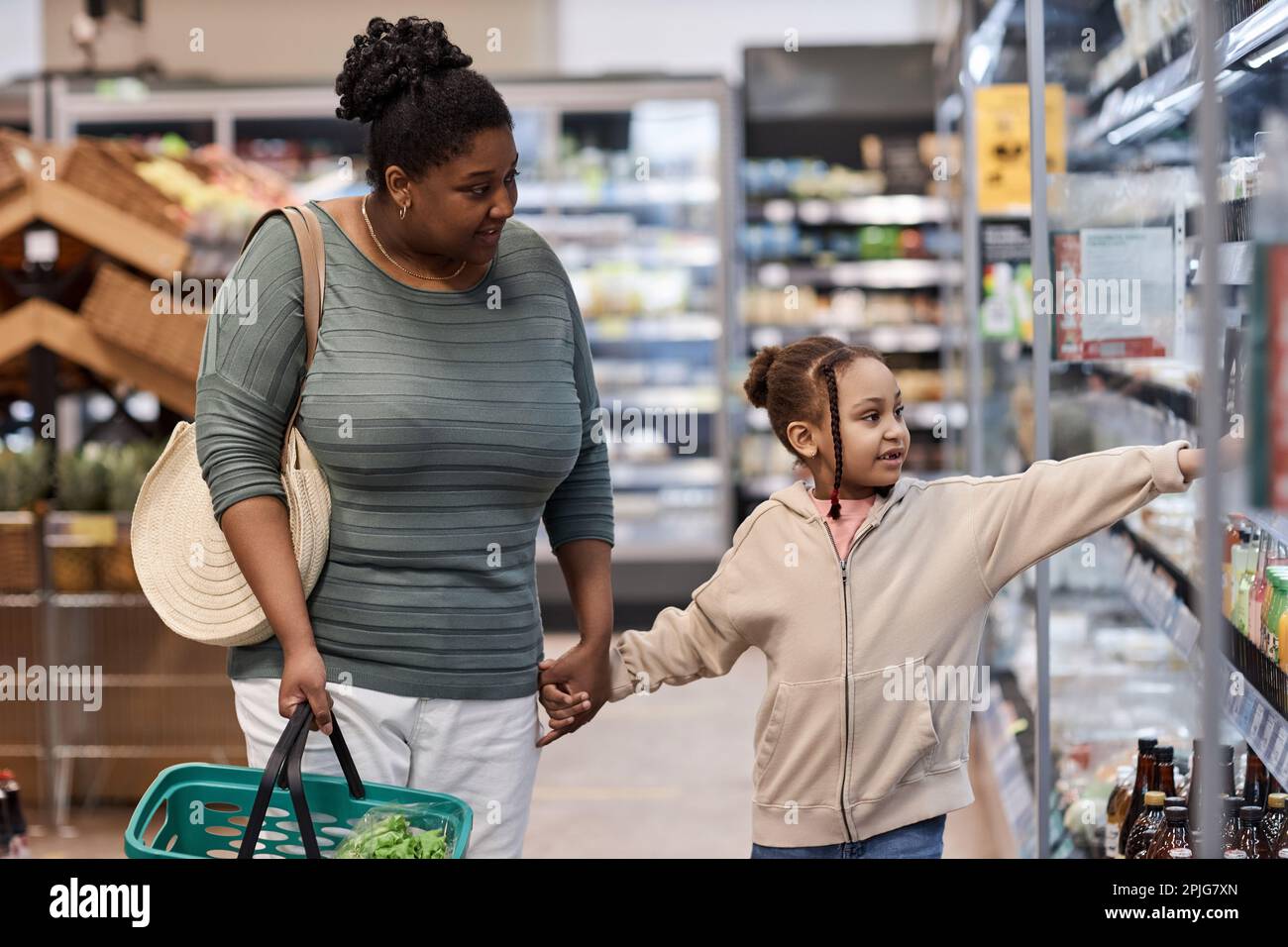 Portrait of mother and daughter in supermarket grocery shopping