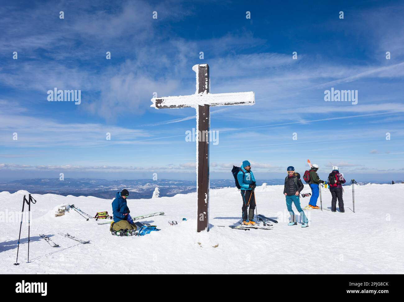 Pilsko, Beskid mountains, Slovakia, Poland - March 12, 2023: Tourists and skialp skier on the top of mountain and hill. Sunny day in the winter. Snow Stock Photo