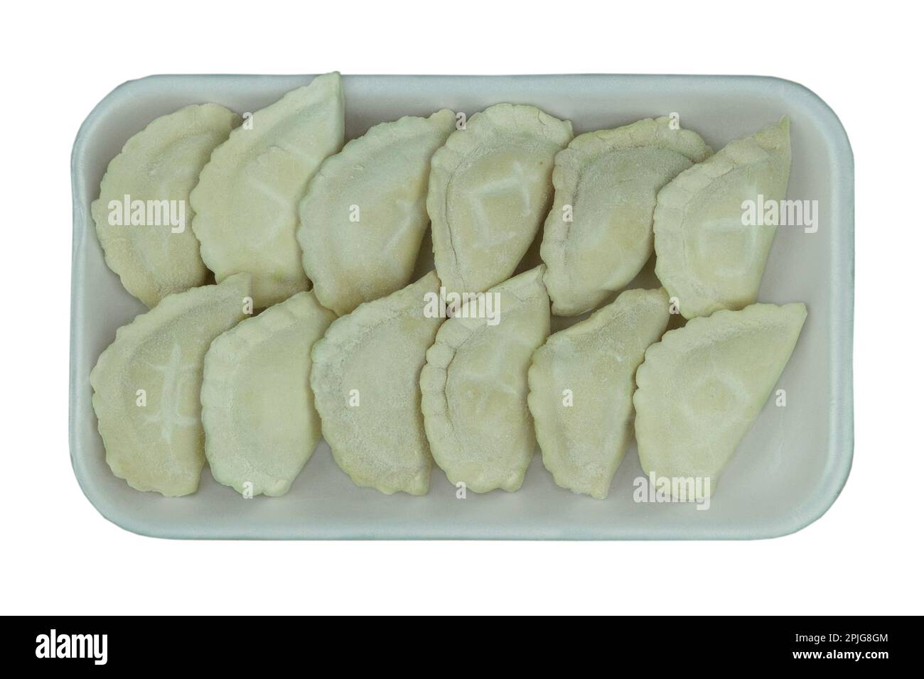 Raw Vareniks with potato filling on a board on a white background. Traditional Ukrainian cuisine. Top view. Stock Photo