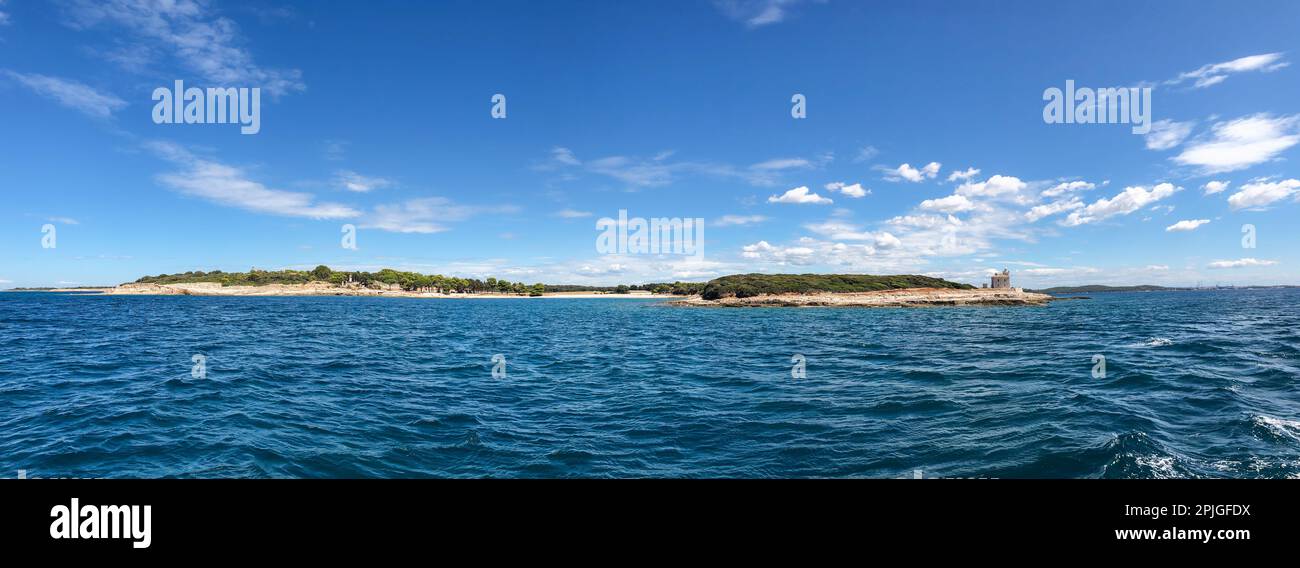 Panorama View of Brionian Island with Cape Peneda. Adriatic Sea Shore with Blue Water and Blue Sky with Clouds during Summer Day in Croatia. Stock Photo
