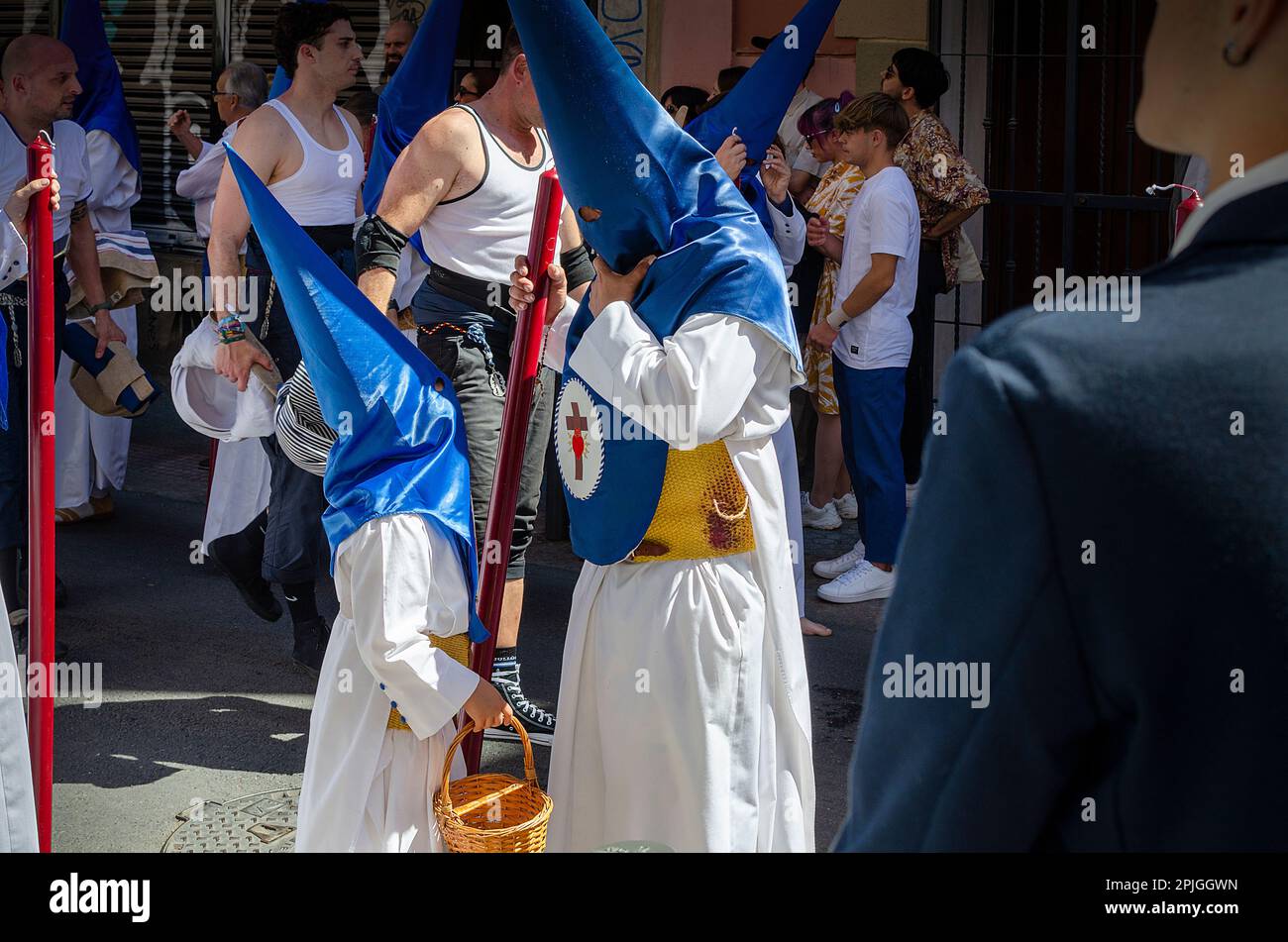 Seville, Spain; April 2, 2024: Nazarenes, father and son, during the procession of the Hiniesta brotherhood. Palm Sunday 2023. Stock Photo