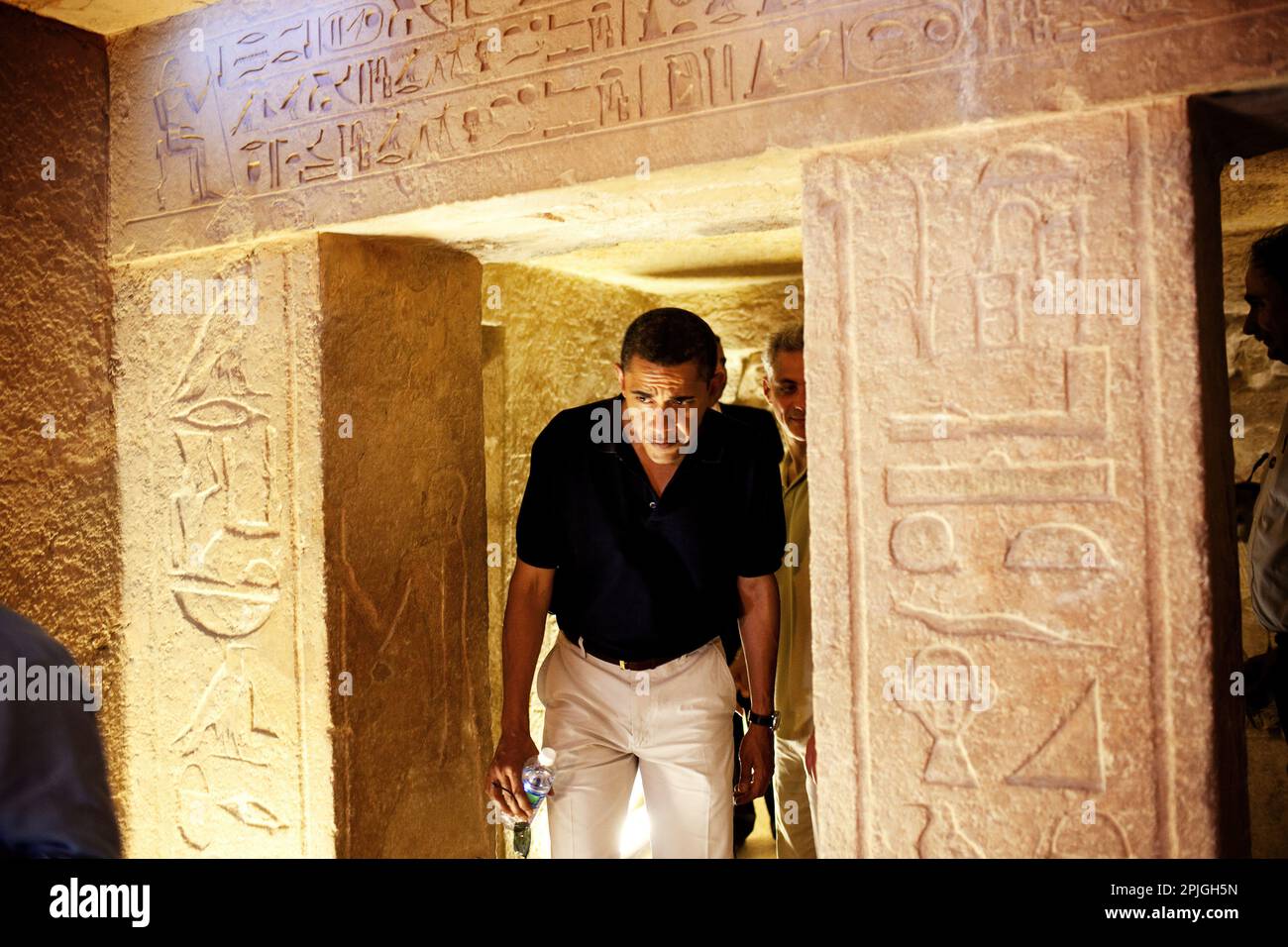 President Barack Obama ducks his head to get through an entranceway on a tour of the Pyramids and Sphinx in Egypt, June 4, 2009.  At center-right is the hieroglyphic that the President comment on saying it looked like him. (Official White House Photo by Pete Souza) This official White House photograph is being made available for publication by news organizations and/or for personal use printing by the subject(s) of the photograph. The photograph may not be manipulated in any way or used in materials, advertisements, products, or promotions that in any way suggest approval or endorsement of the Stock Photo