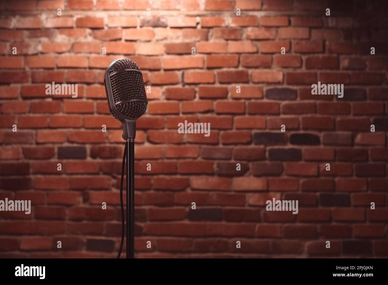 Stand up comedy stage microphone background brick wall. Stock Photo