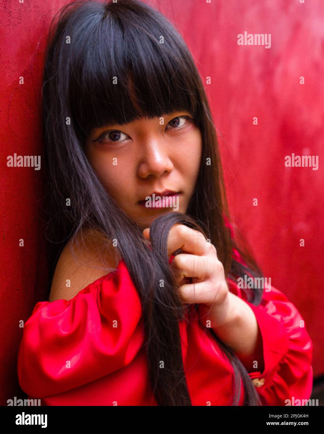 Girl in a red dress leaning against a red wall | Red on Red | Long