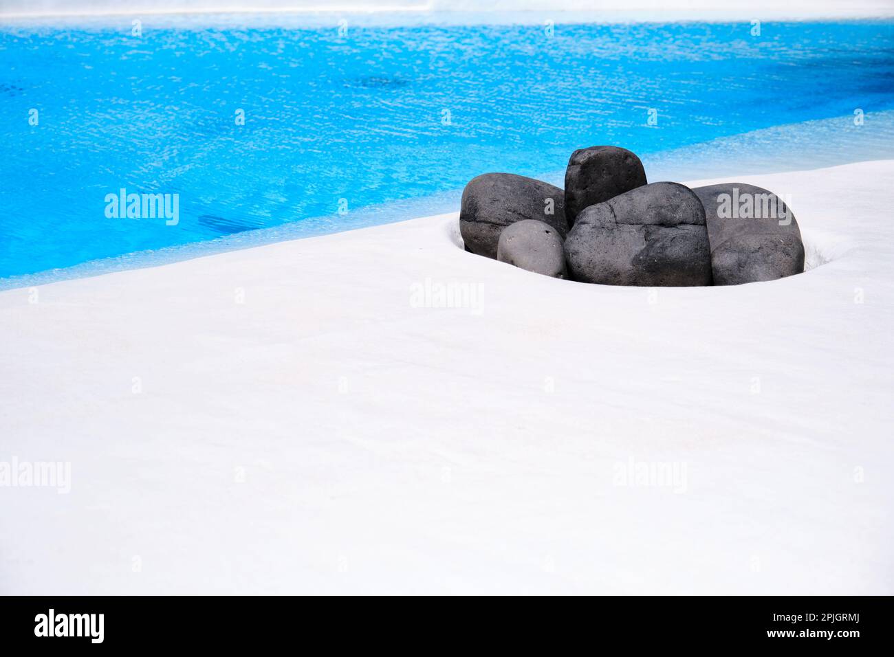 Volcanic stones next to a swimming pool Stock Photo - Alamy