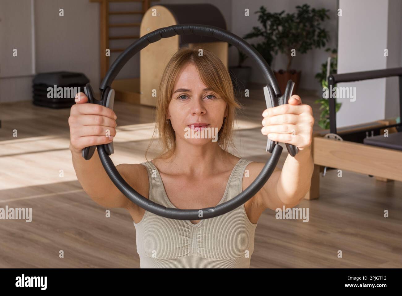 Young sporty attractive women doing pilates toning exercises for abs with flex ring toner