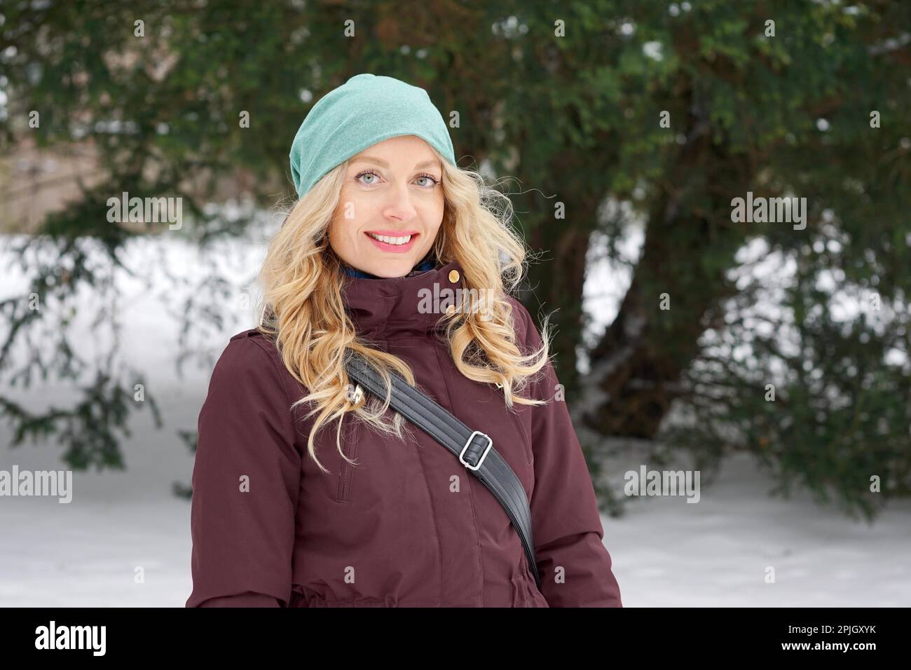 blond woman wearing warm winter fashion and woolen hat enjoying winter Stock Photo