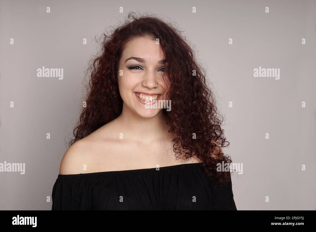 happy teenage girl with long curly hair and a big grin Stock Photo