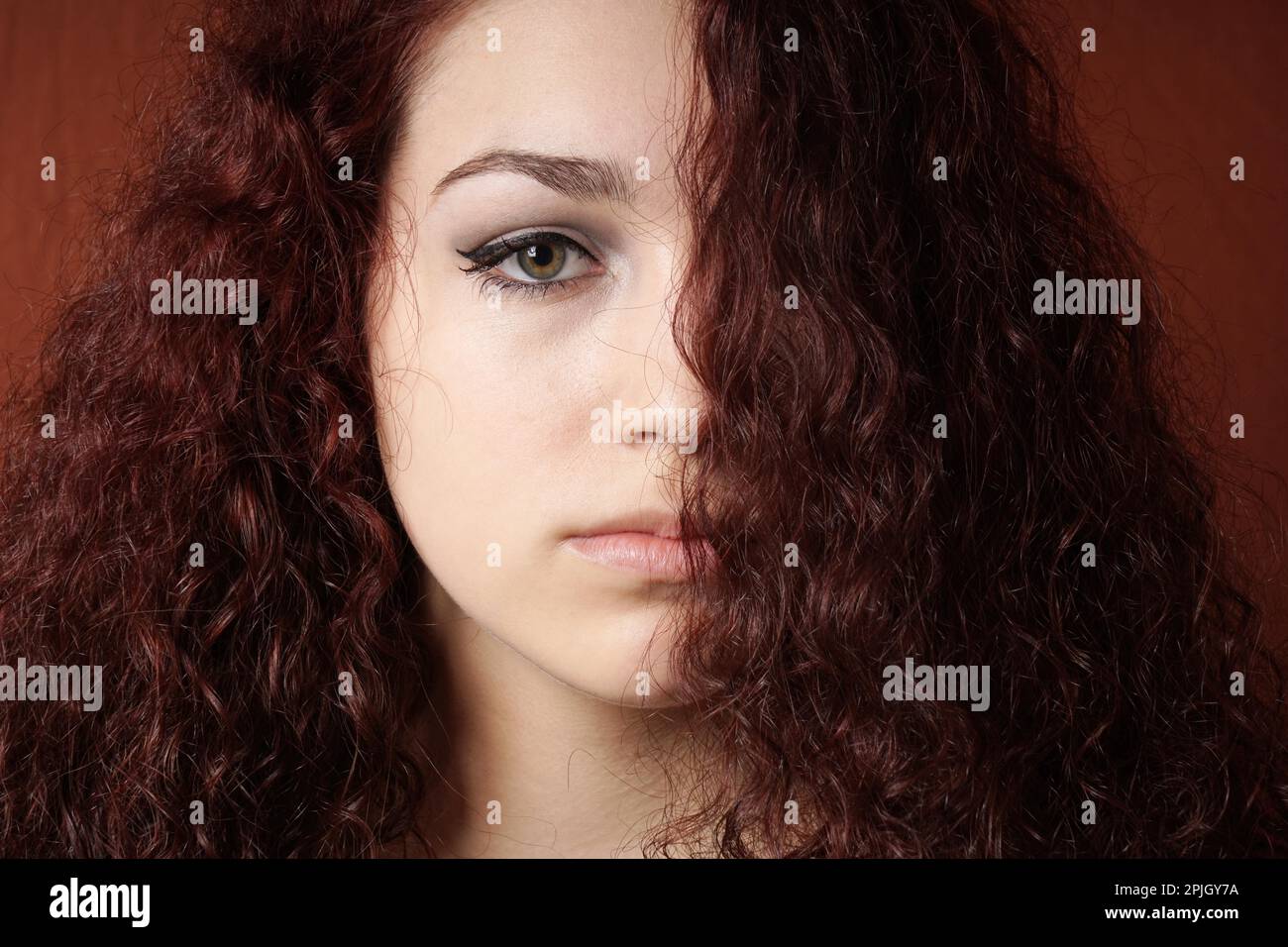 portrait of sullen girl with natural curly long hair Stock Photo - Alamy