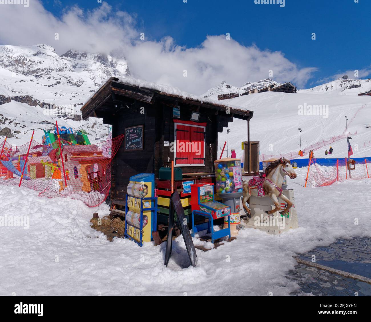 Snow scene with a wooden hut with red window at a childs play area in the ski resort of Breuil-Cervinia in the Aosta Valley Italy Stock Photo