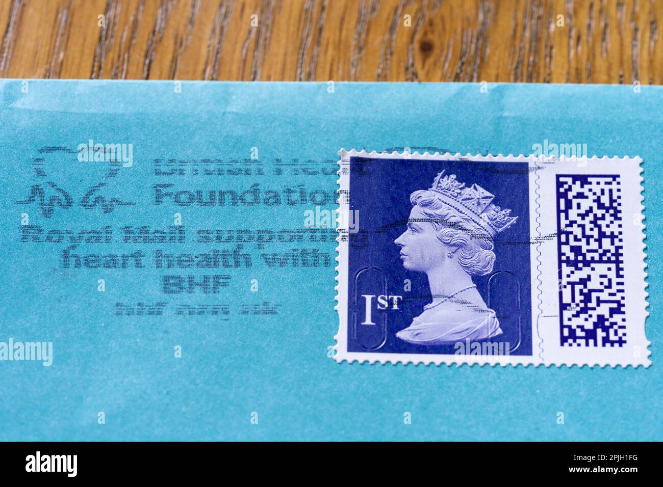 Royal Mail first class Elizabeth II stamp with QR code, on an envelope and franked showing Royal Mail supports charities and charitable causes Stock Photo